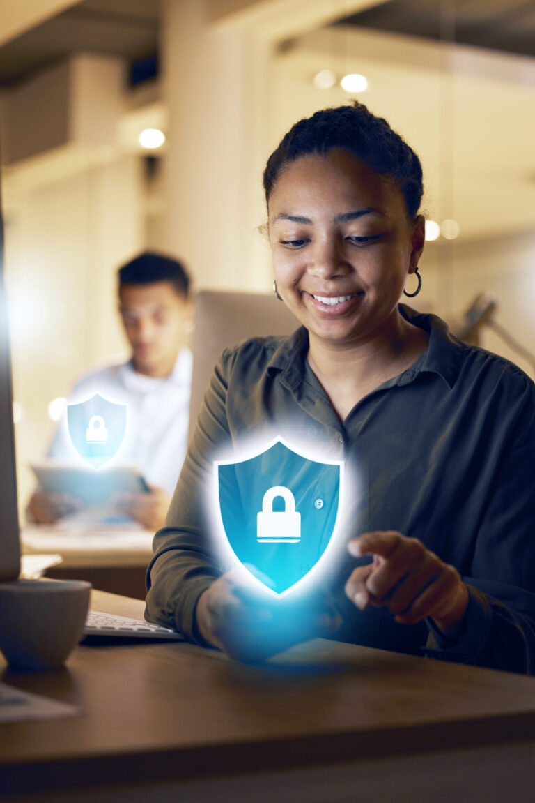 Uma mulher sorri enquanto usa seu smartphone em uma mesa, com um ícone brilhante de cadeado digital e escudo sobreposto, simbolizando a segurança cibernética - ideal para quem busca um sistema para lotéricas seguro. Uma pessoa trabalha ao fundo com um ícone semelhante.