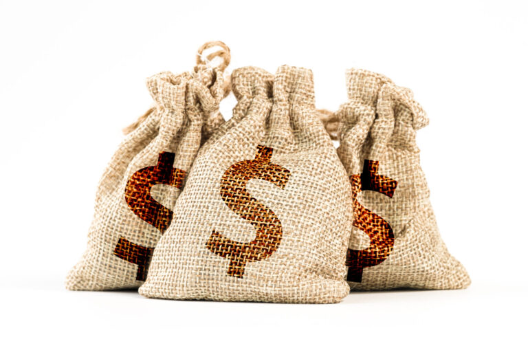 Três sacos de dinheiro de serapilheira com grandes cifrões impressos estão agrupados em um fundo branco, sugerindo maneiras de melhorar o aproveitamento de malotinhos na gestão financeira.